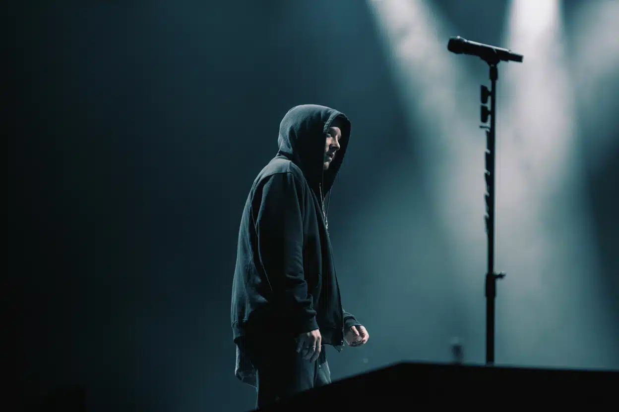 Is Eminem retiring? A shadowed Eminem walks off stage alone, fueling speculation about his future in music.